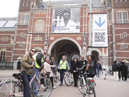 students on bikes in front of old building