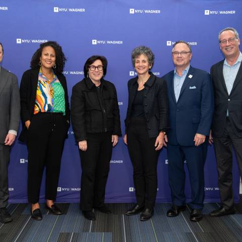 group posing in front NYU Wagner backdrop