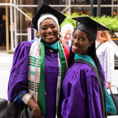 Two graduates outside City Center
