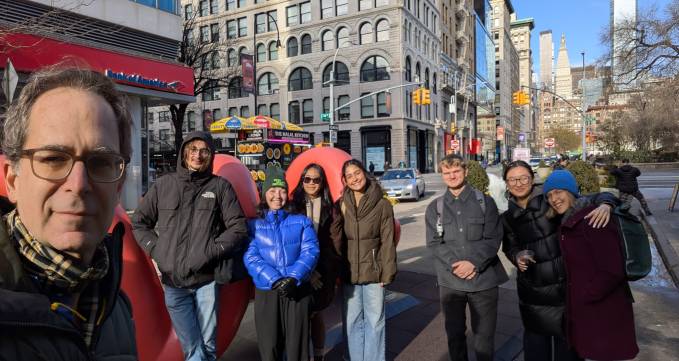 group of students posing for photo in city street